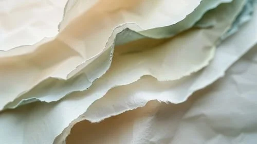 Three abstract handmade paper pieces in white and blue tones with soft, irregular edges