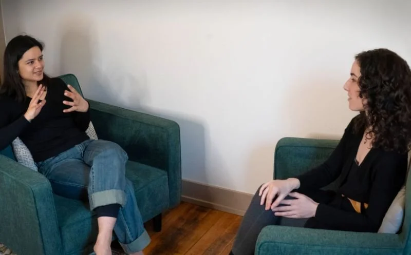 Thoughtful moment of therapeutic connection during somatic counselling session with female client